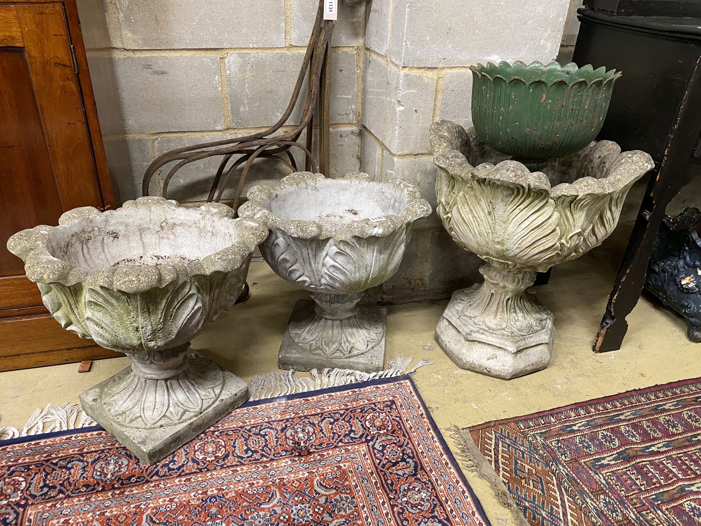 A pair of reconstituted stone acanthus garden planters, a similar larger planter and a cast iron urn, largest diameter 50cm, height 58cm